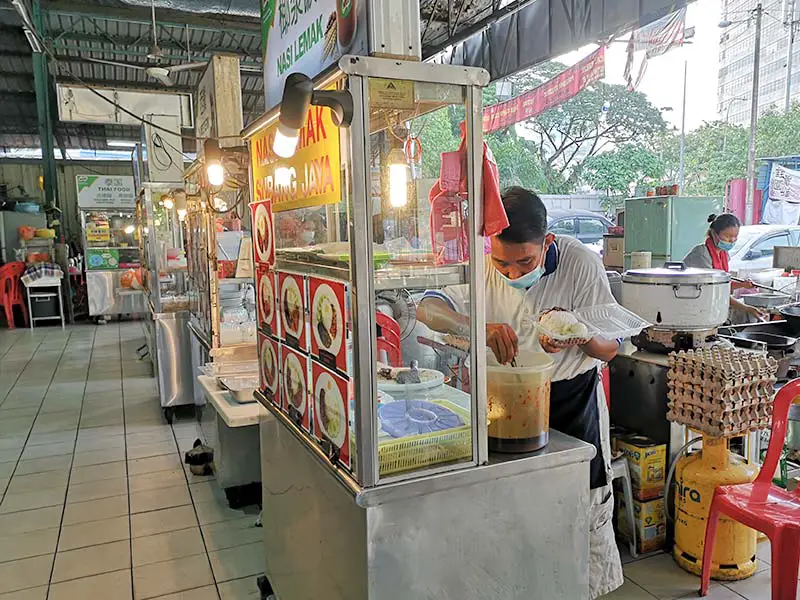 uncle-scooping-the-sambal-sauce-onto-the-nasi-lemak